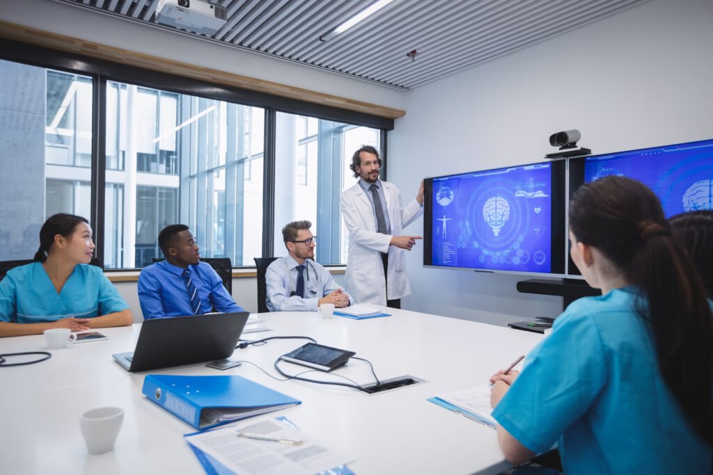 Doctor giving presentation to team of interim doctors at conference room