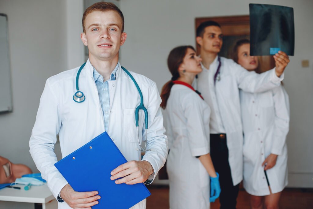 Doctor with a folder in his hands looks at the camera . Students practice medicine. Men and women examine an x-ray.
